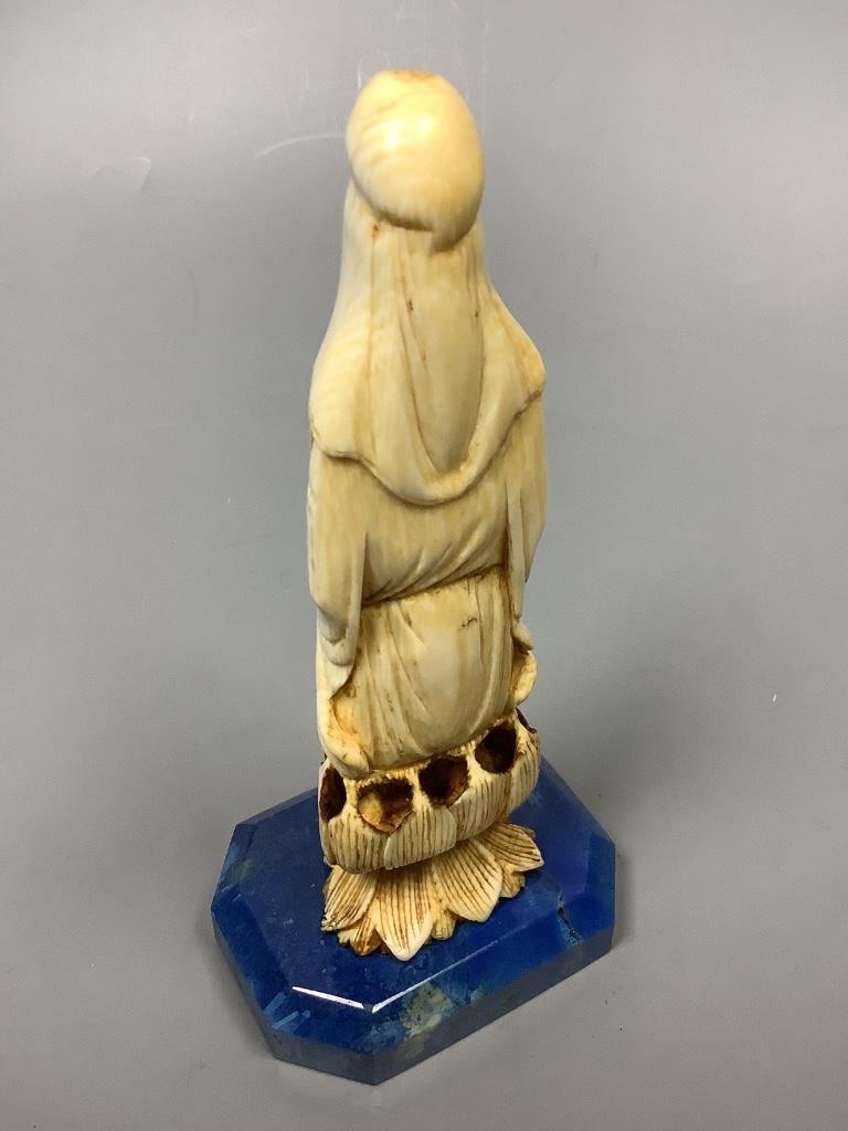 A 19th century Chinese carved ivory Guanyin, on a later lapis lazuli base, height 14cm